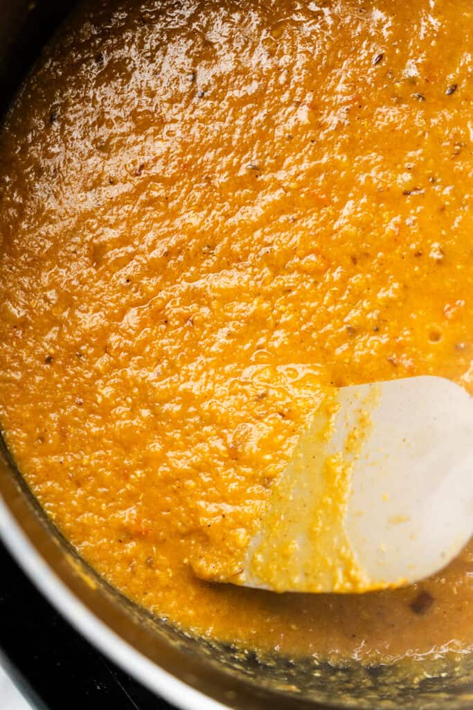 the cooked red lentil dahl curry in a pot.