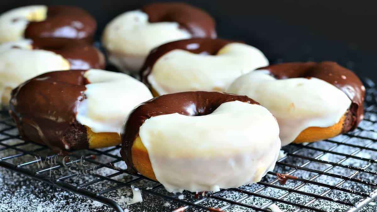 A close-up photo of a stack of yeast donuts glazed in black and white frosting.