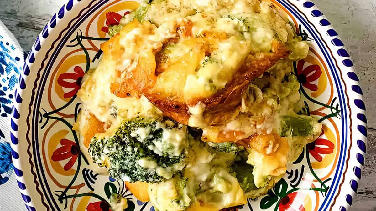 a vlose up image of Cheesy Cheddar Broccoli Casserole in a colorful bowl.