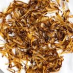 Crispy fried onions spread on a paper towels.
