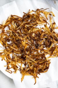 Crispy fried onions spread on a paper towels.