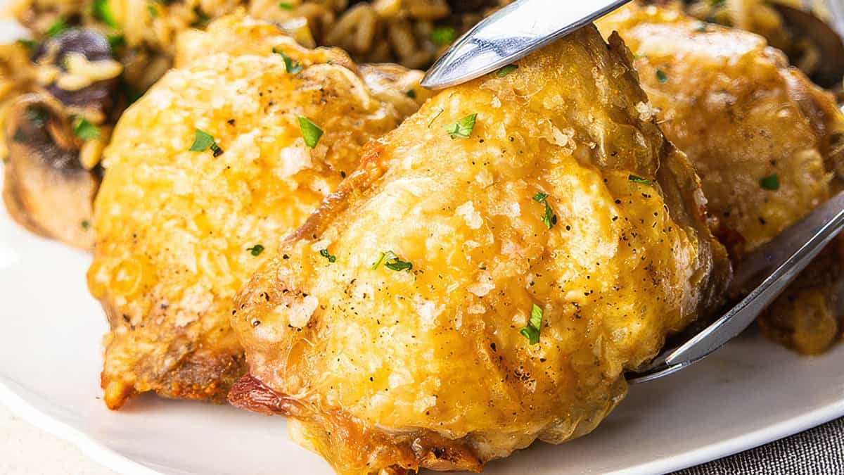 Crispy Oven Baked Chicken Thighs on a plate with some rice.