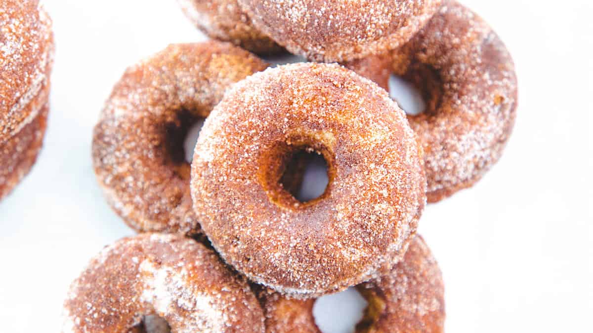 A pile of Cinnamon Sugar Donuts with a white background.