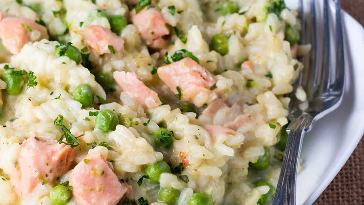 Easy Salmon and Pea Risotto on a white dish with a fork next to it.