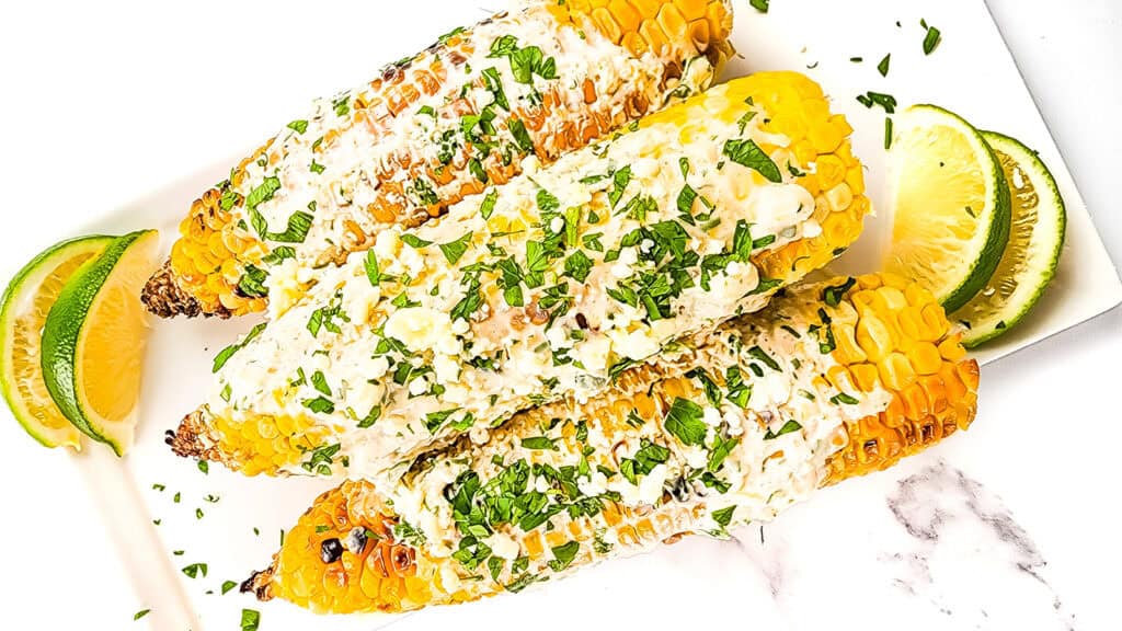 Mexican Street Corn covered in a sour cream sauce and crumbled cheese.