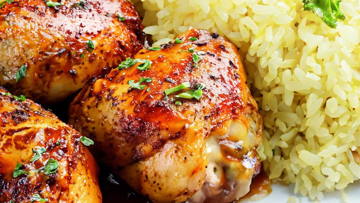 Peri Peri Chicken thighs on a plate with yellow rice.