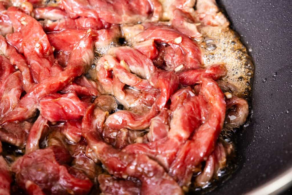 Steak cooing in a wok.