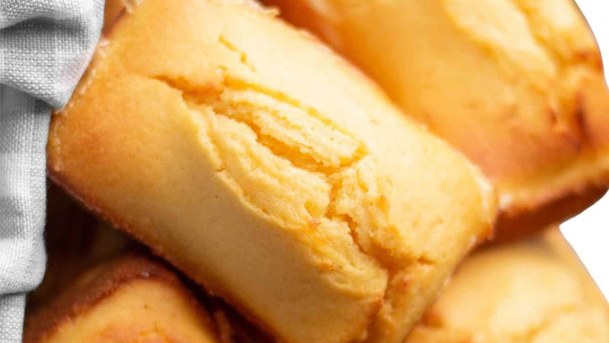 Close-up dari kue spons berwarna coklat keemasan dengan tekstur lembut dan halus-suguhan klasik yang mengingatkan pada resep selatan tercinta-terutama ditutupi oleh kain abu-abu muda.