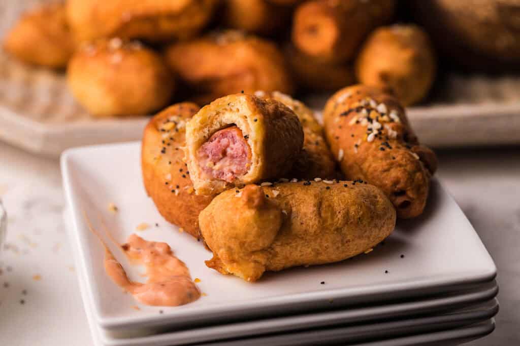 A close up image of Everything Bagel Beer Dogs. on a white plate.