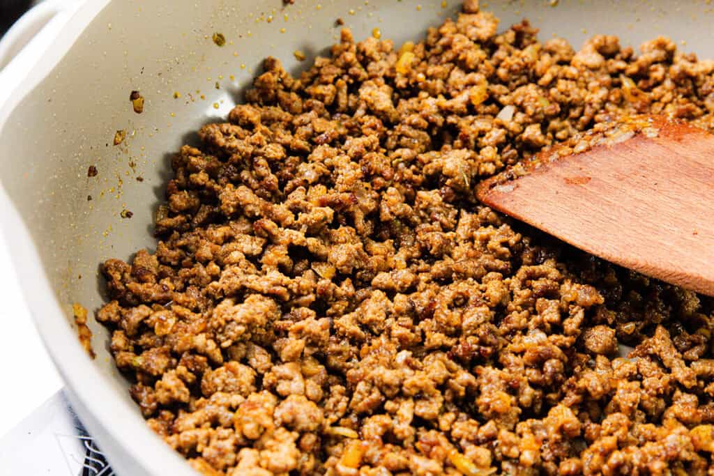 Ground beef cooked in a skillet with smoky homemade seasoning, being stirred with a wooden spatula—perfect for flavorful ground beef tacos.
