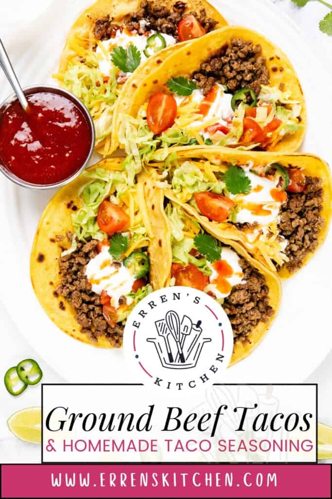 Three Ground Beef Tacos With Homemade Taco Seasoning are topped with shredded lettuce, cherry tomatoes, sour cream, and cilantro, served with salsa, jalapeño slices, and lime wedges. Text reads “Ground Beef Tacos & Homemade Taco Seasoning.”.