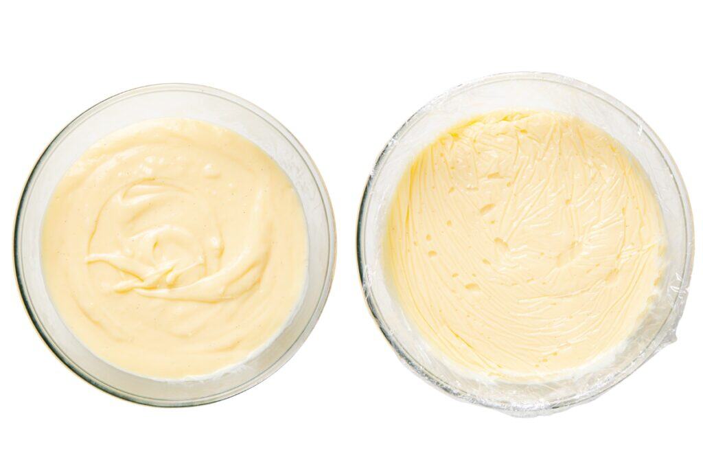 Two glass bowls filled with pale yellow custard evoke classic Banana Cream Pie—smooth in the uncovered bowl on the left, while the right bowl, covered with plastic wrap, keeps this old-school pie favorite fresh and creamy.