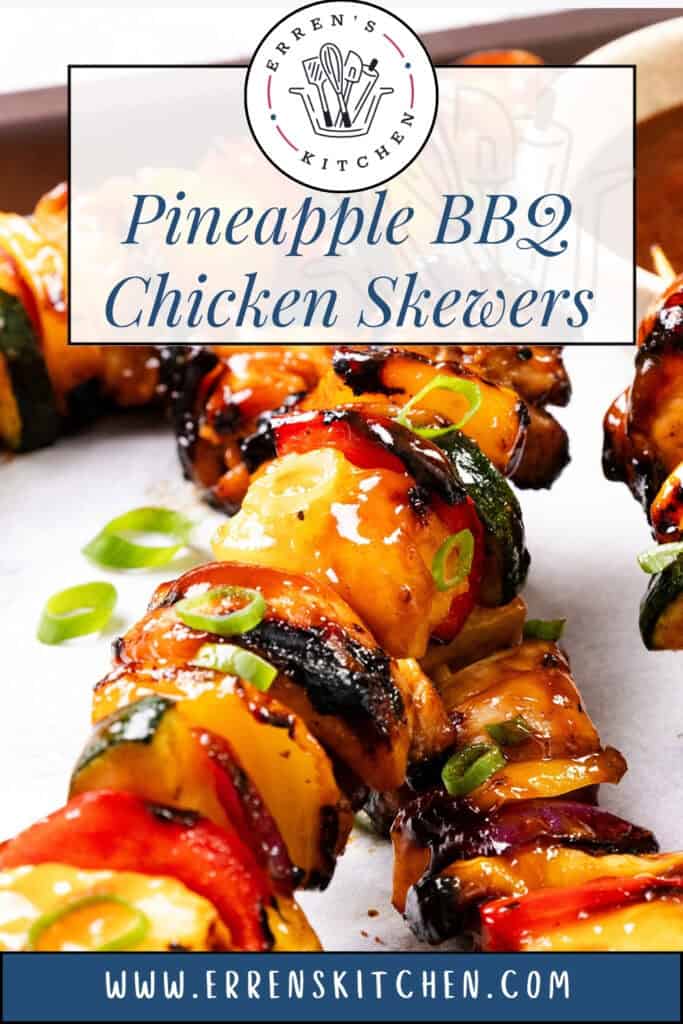 Close-up of Pineapple BBQ Chicken Skewers with peppers and zucchini, glazed to perfection and garnished with green onions on parchment paper. Text overlay reads “Pineapple BBQ Chicken Skewers” from Erren’s Kitchen.