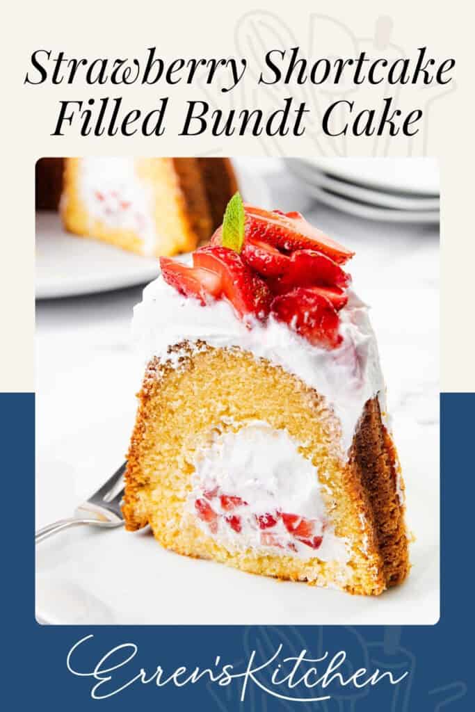 A slice of filled Bundt Cake with whipped cream and strawberries inside, topped with more whipped cream, fresh sliced strawberries, and a mint leaf, served on a white plate with a fork.