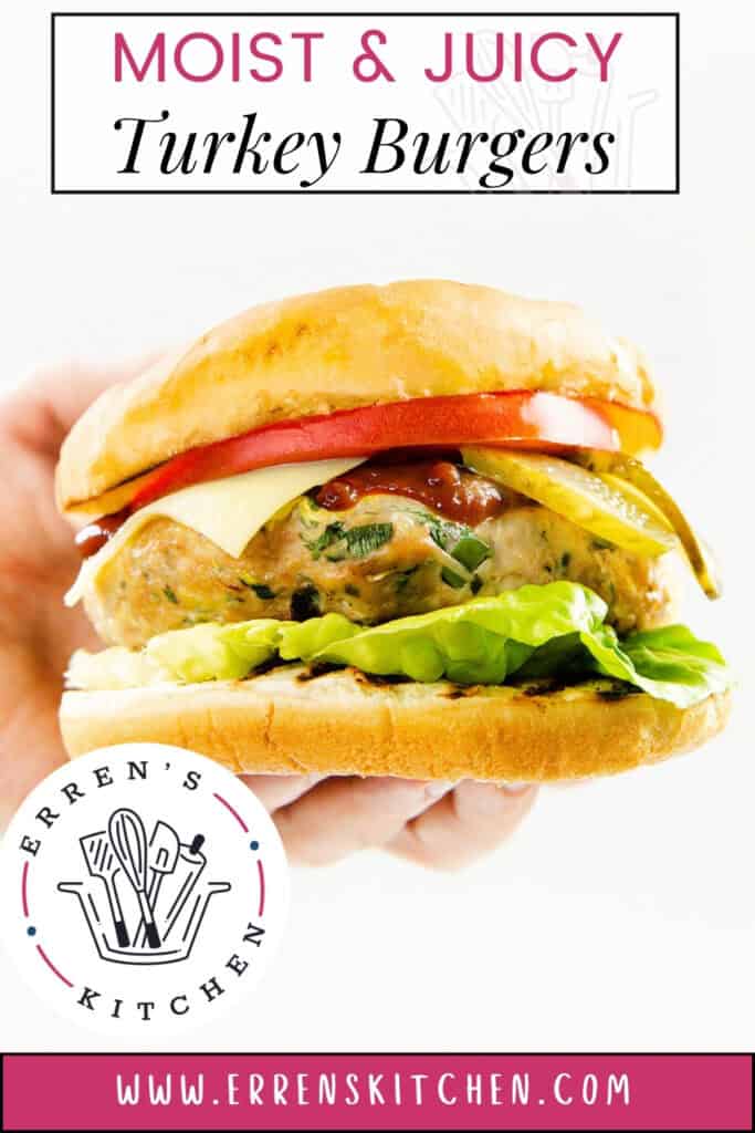 A hand holds one of Erren’s Kitchen’s turkey burgers, stacked with lettuce, tomato, pickles, cheese, and sauce in a bun. The text reads "Moist & Juicy Turkey Burgers" and www.errenskitchen.com.