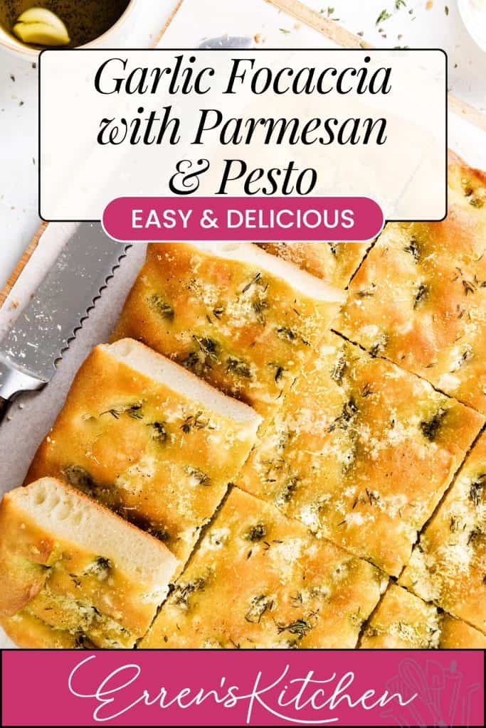 A sliced Garlic Focaccia topped with herbs, Parmesan, and pesto sits on a wooden board beside a serrated knife; text overlay reads “Garlic Focaccia with Parmesan & Pesto, Easy & Delicious, Erren’s Kitchen.”.