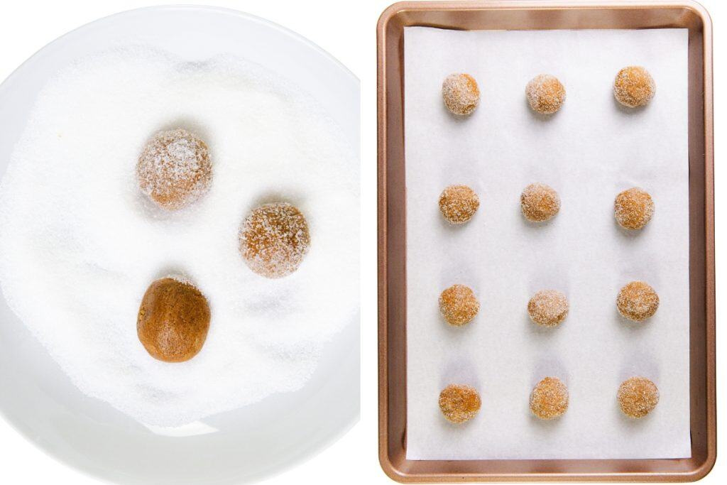 Four round dough balls being coated in sugar on a white plate, next to a baking sheet lined with parchment paper holding twelve evenly spaced gingersnap cookies ready to be baked.