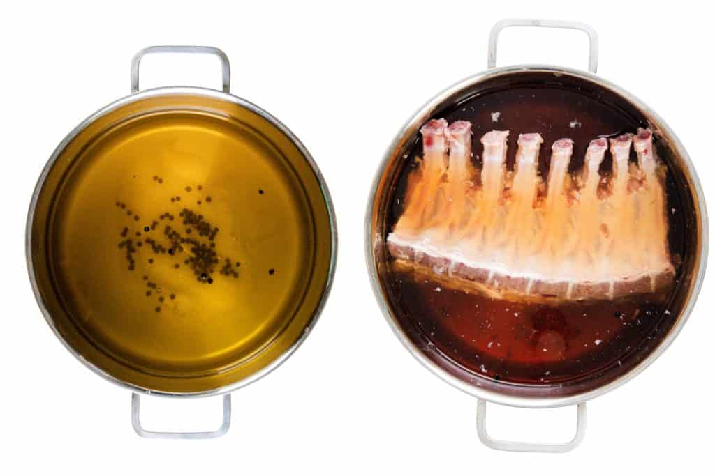Two metal pots viewed from above: the left pot holds a brine liquid with floating peppercorns, while the right pot features brined pork rib roast submerged in a dark marinade.
