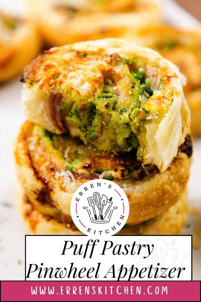 Tampilan jarak dekat dari kincir kue puff emas bersisik yang diisi dengan herba hijau dan bahan lainnya, dengan satu gigitan diambil. Hamparan teks terbaca "Pembuka Kincir Puff Pastry"—tambahan yang menggoda untuk makanan pembuka puff pastry Anda—di errenskitchen.com.