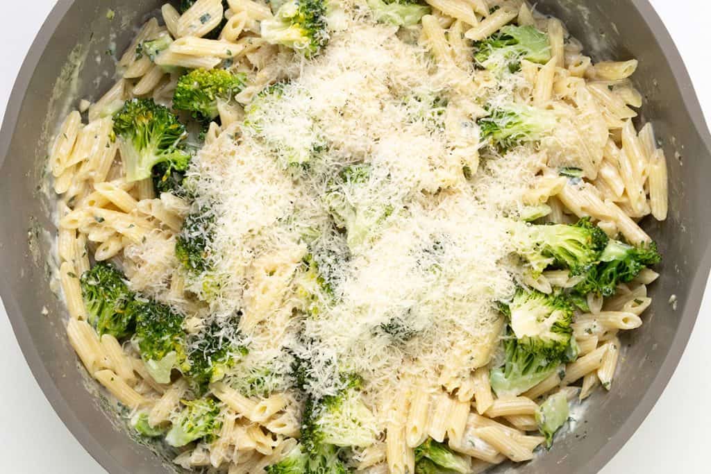 A pan filled with creamy garlic pasta, tender broccoli florets, and a generous topping of grated Parmesan cheese makes for the perfect one-pot pasta dish.