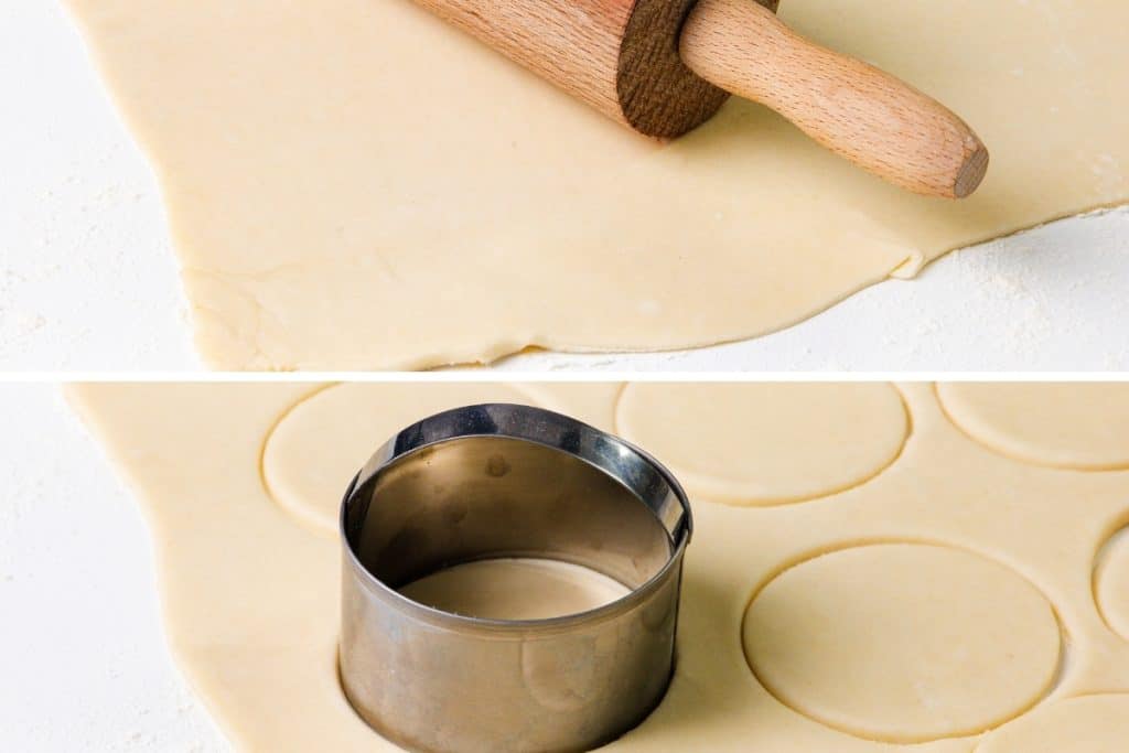 A wooden rolling pin on rolled-out dough, with a metal biscuit cutter shaping circles for mini quiches&mdash;perfect party appetizers inspired by classic quiche recipes&mdash;on a floured surface.
