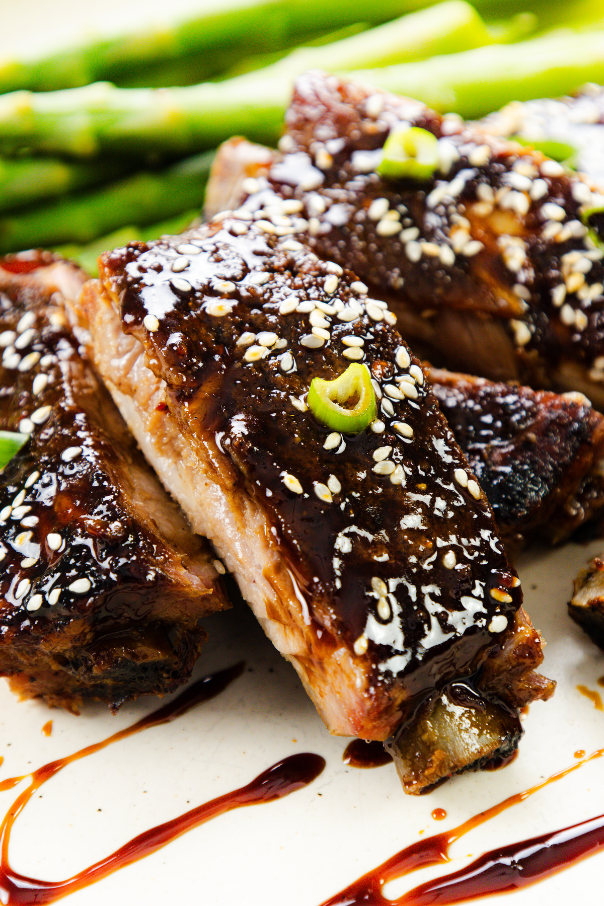 A plated serving of Asian style pork ribs with sesame seeds and green onions.