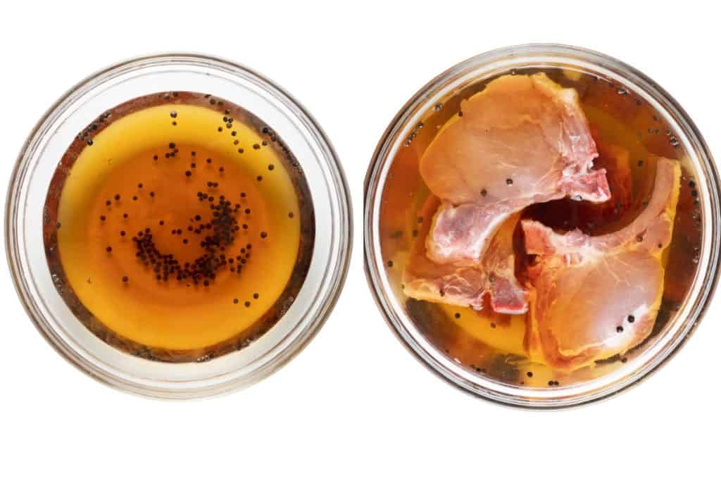 Two glass bowls from above: one with a brown marinade featuring black pepper seeds, the other holding brined pork chops soaking in a Sriracha soy glaze. Both are placed on a white background.