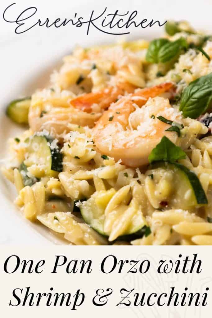 Close-up of orzo pasta tossed with juicy shrimp, tender zucchini, grated cheese, and fresh basil on a white plate. Text: “Erren’s Kitchen” and “One Pan Orzo with Shrimp & Zucchini.”.