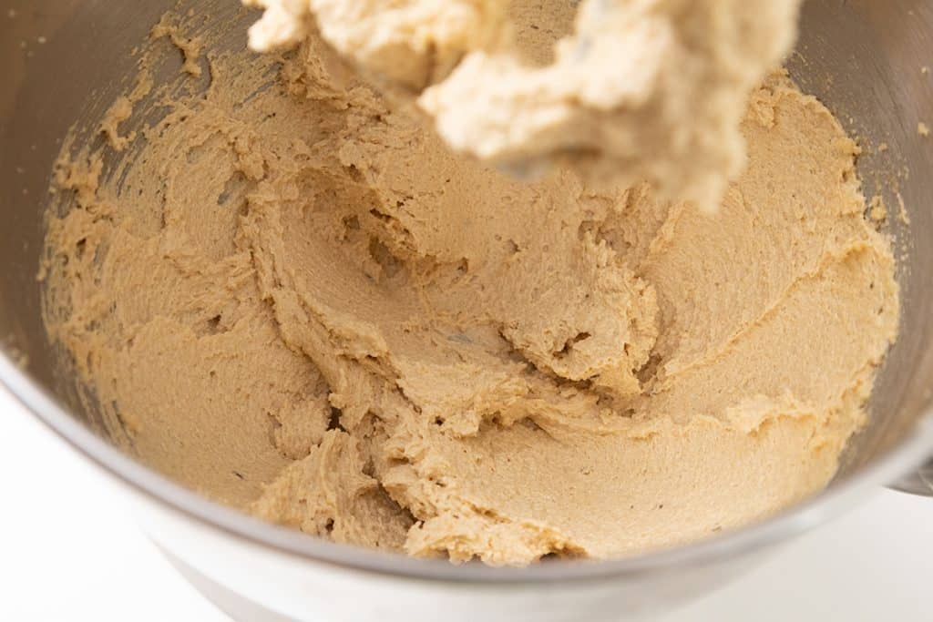 Creamed butter and sugar mixture in a metal mixing bowl for pumpkin spice cookie bars.